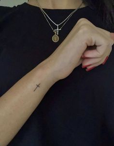 a woman with a cross tattoo on her arm