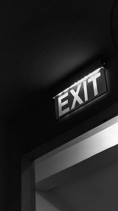 an exit sign is lit up in black and white with the word exit above it