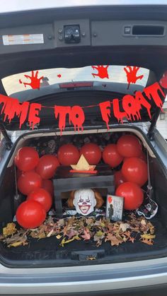 the trunk of a car decorated with balloons and decorations for halloween time to float on