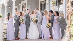 a group of people standing next to each other in front of a white fence and building