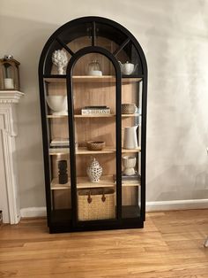 an arched glass display cabinet in a living room