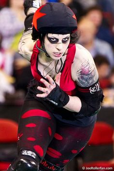 a woman in black and red is riding on roller skates