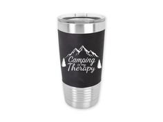 a stainless steel tumbler cup with the words camping is therapy on it and mountains in the background