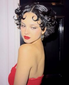 a woman in a red dress with curly hair and earrings on her head, looking off to the side