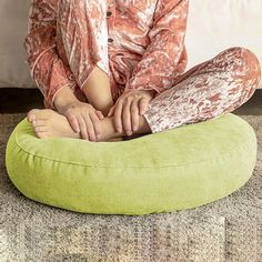 a woman sitting on top of a green bean bag chair