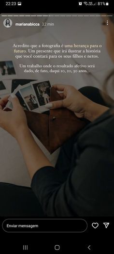 a woman holding an open book on top of a table