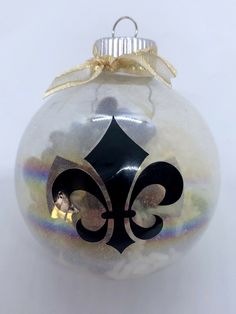 a glass ball ornament with a fleur de lis design on it