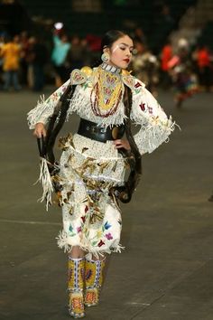 a woman is walking down the runway in an elaborate outfit