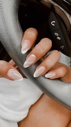 a woman with long nails holding onto a car steering wheel