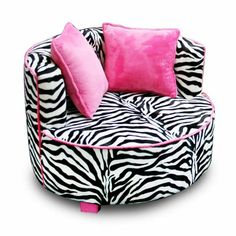 a zebra print chair with pink pillows on it