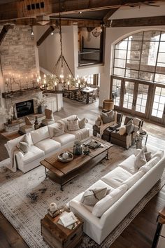 a living room filled with white furniture and lots of windows in the wall next to a fireplace