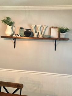 two wooden shelves with letters on them and some plants in vases next to each other