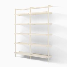 a white book shelf with four shelves on each side and one in the middle, against a wall