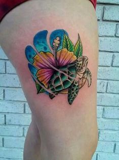 a woman's thigh with a turtle and flower tattoo on it