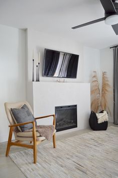 a living room with a large flat screen tv on the wall and a fire place