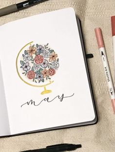 an open notebook with flowers and the word merry written in cursive writing on it