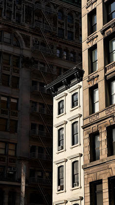 an image of a building that is in the daytime light with fire escapes on it