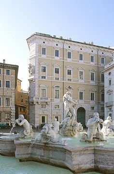 the fountain is surrounded by statues and buildings