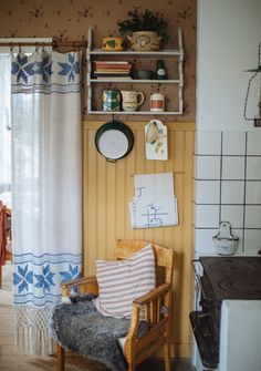 a chair in a room with a shelf above it and other items on the wall