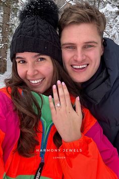 a man and woman standing next to each other in the snow with their hands together