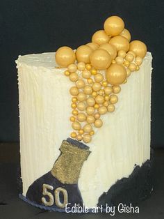 a 50th birthday cake decorated with gold balloons and a wine bottle on the bottom layer