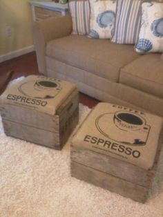 three wooden boxes sitting on the floor in front of a couch with pillows and throw pillows