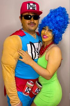 a man and woman dressed in costumes posing for a photo together, one is hugging the other