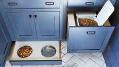 two bowls with food in them sit on the floor next to some cabinets and drawers