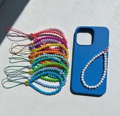 a cell phone case with beads and a string of hair clips on top of it