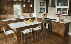 a kitchen with wooden cabinets and white counter tops, along with an island in the middle