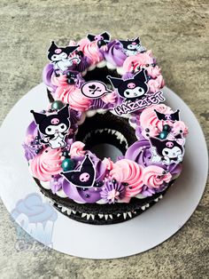 there is a cake decorated with cats and skulls on the top, sitting on a plate