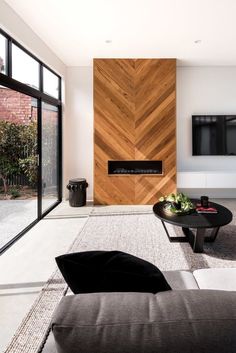 a modern living room with wood paneling and white walls, large windows on the side