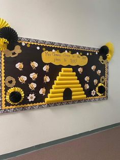 a bulletin board with bees and honeycombs on it's side in a school hallway