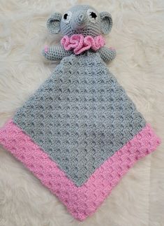 a crocheted elephant blanket with a pink bow on it's head and tail