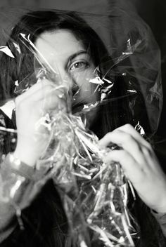 black and white photograph of a woman wrapped in plastic