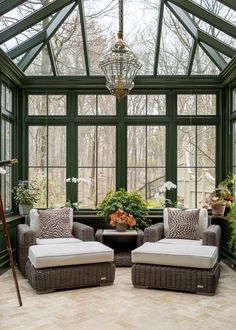 a sun room with two chairs and a table