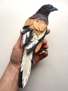 a hand holding a bird made out of paper