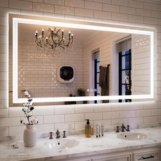 a bathroom sink with a large mirror above it and a chandelier hanging from the ceiling