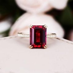 a close up of a ring with a red stone