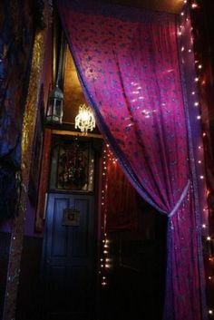 a purple canopy with lights hanging from it's sides in front of a doorway