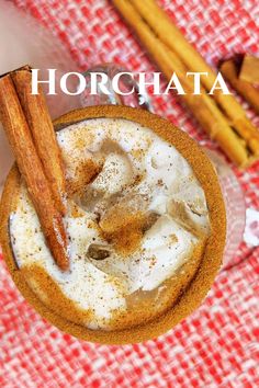 an overhead view of a drink with cinnamon sticks in the foreground and text overlay that reads horchata