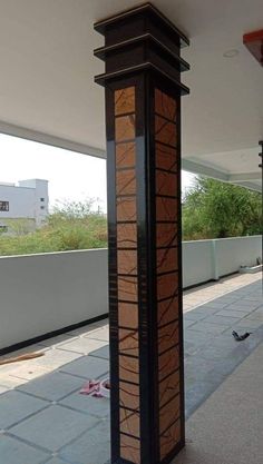 a tall wooden tower sitting on top of a cement floor next to a building with lots of windows