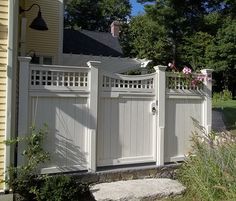 a white fence and gate in front of a house