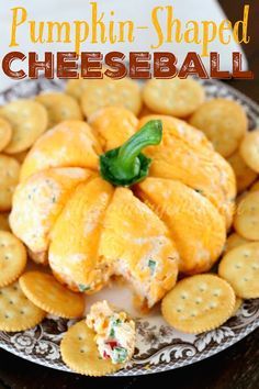 pumpkin shaped cheeseball on a plate with crackers