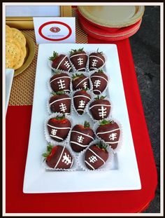 chocolate covered strawberries are arranged on a white platter with crackers and cookies