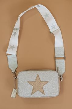 The idyllic casual bag to style with limitless looks! Compact crossbody bag with an all white design. Gold star engraving. Single top zip closure. Silvertone hardware. One inside zip pocket. Adjustable sporty star strap design.SIZE Removable, adjustable crossbody strap, 12" to 24" drop 8"W x 5"H x 2.5"D Packaged with love and shipped from our warehouse in Wilmington, Ohio Star Purse, Teenager Birthday Gifts, Bday Wishlist, Preppy Bags, Teenager Birthday, Casual Purse, Zach Bryan, Aesthetic Pastel, Fancy Bags