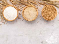 three wooden spoons filled with different types of grain on top of a white surface