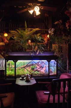 a fish tank in the middle of a table with two chairs and a light fixture above it