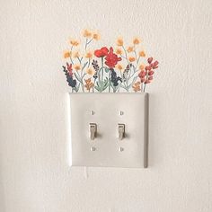 an electrical outlet with flowers painted on it