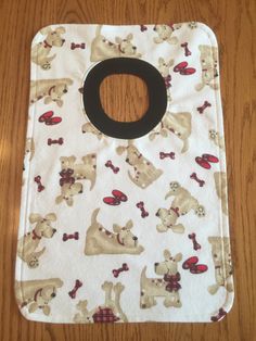 an oven mitt with dogs on it sitting on a wooden floor next to a table